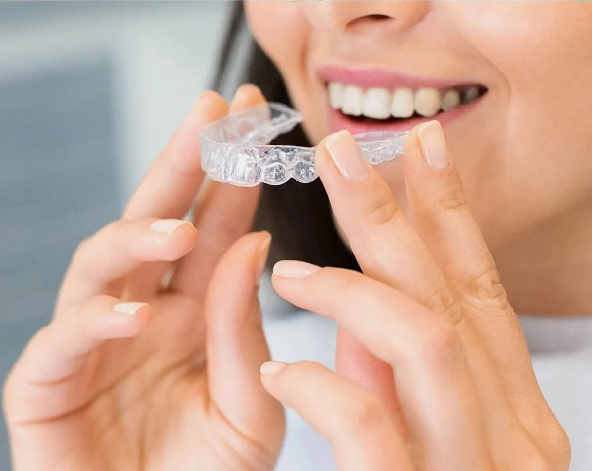 A woman about to put in a clear aligner.
